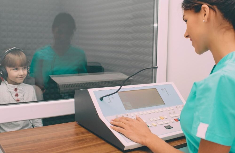 Fonoaudióloga infantil avaliando criança para diagnóstico e laudo de TPAC