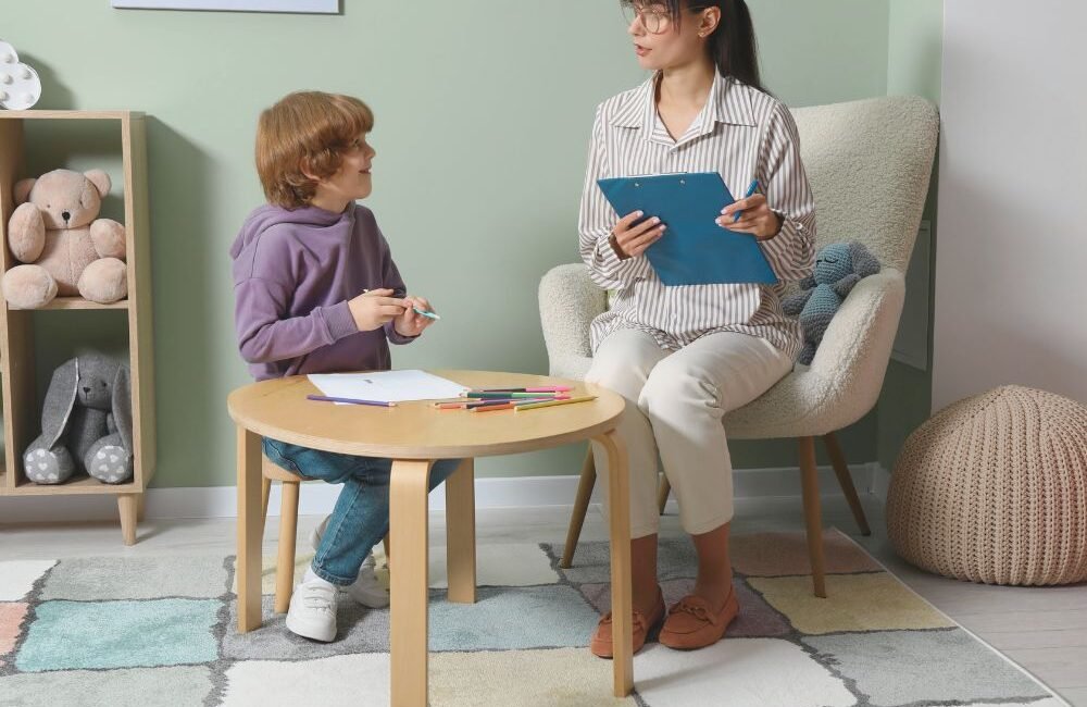 Fonoaudióloga conversando com a criança enquanto ela brinca durante primeira consulta.