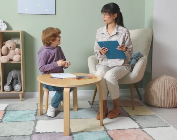 Fonoaudióloga conversando com a criança enquanto ela brinca durante primeira consulta.