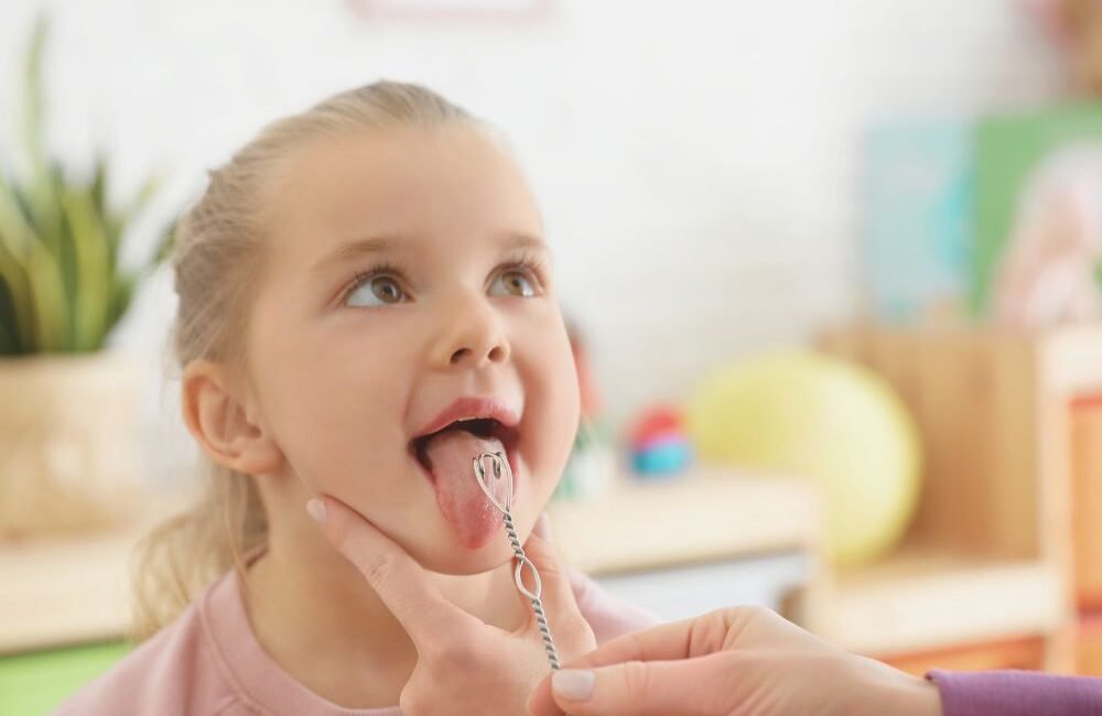 Fonoaudióloga infantil trabalhando com criança durante terapia de linguagem.