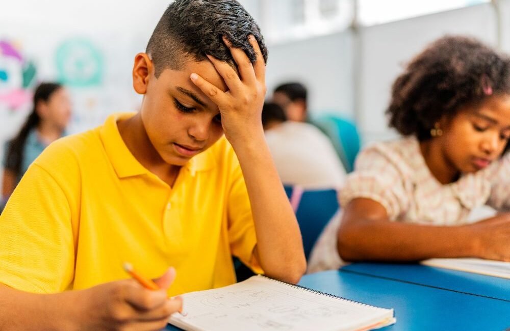 Criança estudando com dificuldade para compreender atividade escolar