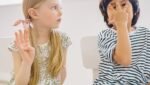 Criança em atividade escolar com dificuldade de comunicação e atenção auditiva