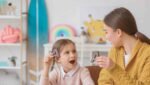 Criança em atividade de compreensão da linguagem com fonoaudióloga infantil.
