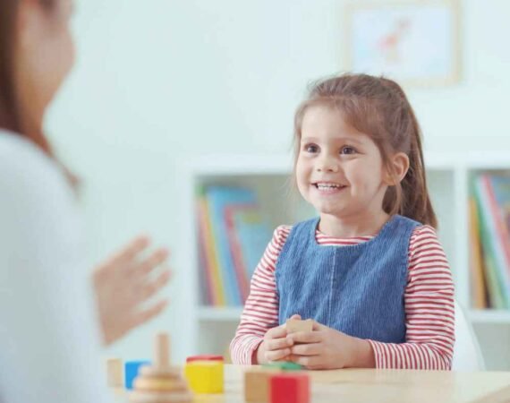 Fonoaudióloga infantil acompanhando criança durante uma atividade de linguagem.